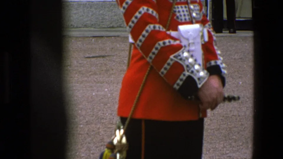 Close side frame from 1969 Buckingham Palace footage showing a Grenadier Guard uniform, belt pouch, sleeve trim, and ceremonial equipment.