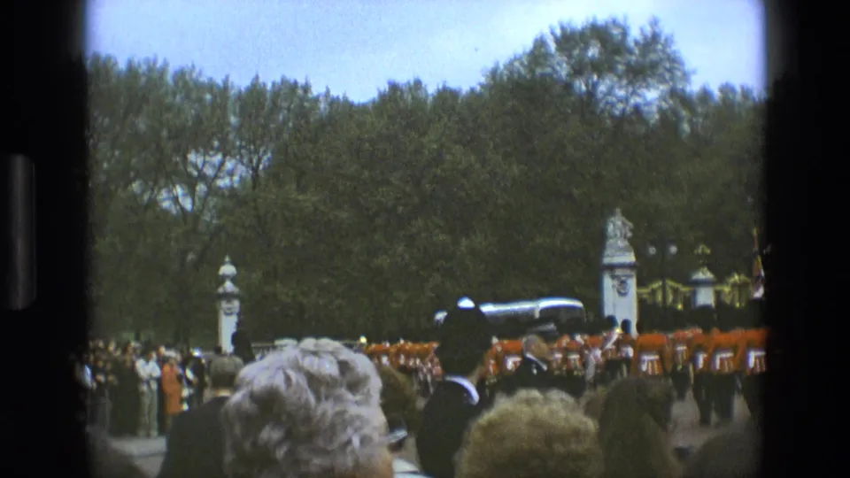 Foreground spectators look toward the Grenadier Guards Band lined up on the parade ground in 1969 England.