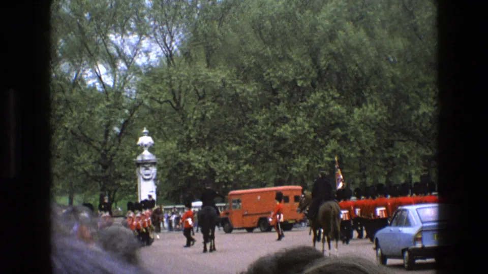 1969 England home-movie frame of guards and mounted personnel near vehicles during a Buckingham Palace ceremony.