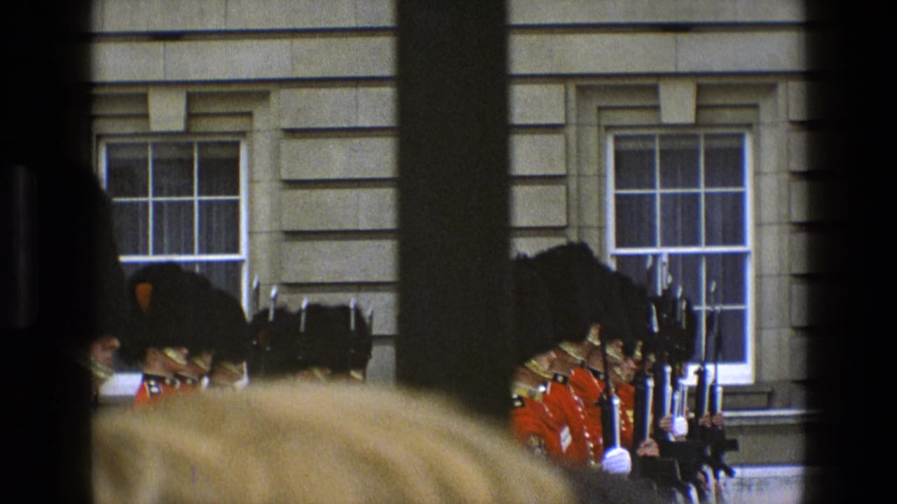 A row of red-coated guards with rifles is seen through dark foreground framing.