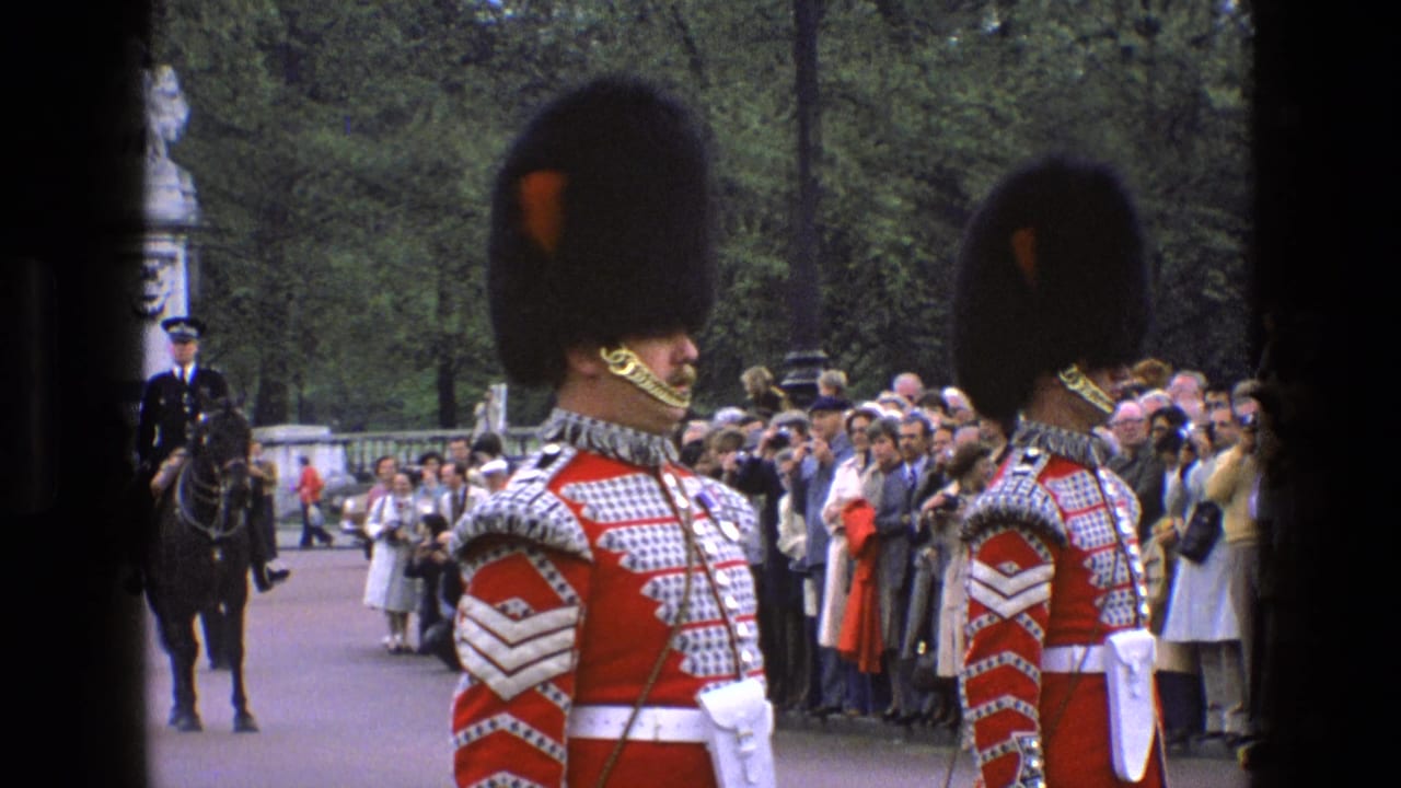 Guards in ceremonial dress stand near crowds with a mounted officer in the background.