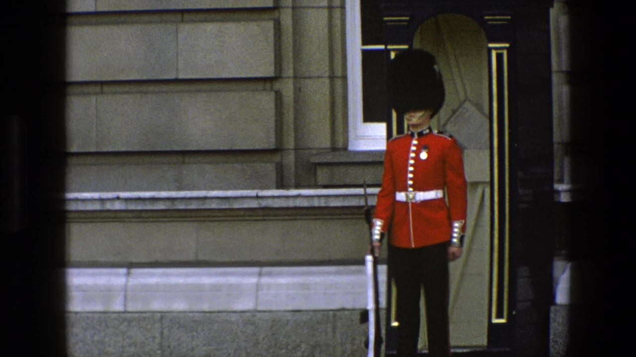 Queen's Guard standing at attention outside a stone building entrance.