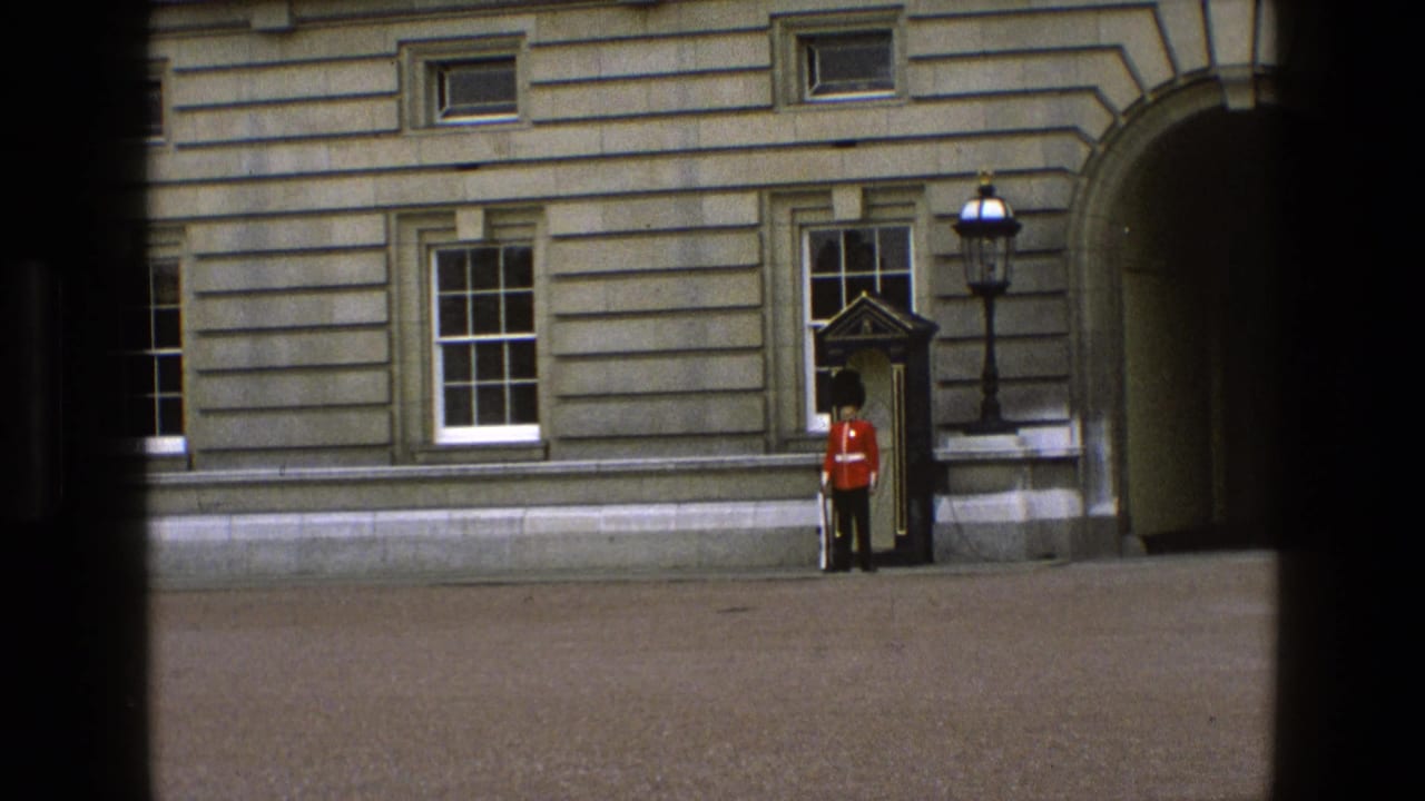 1969 England visitor-shot frame with a distant ceremonial guard by a sentry box near windows and an arched entrance.