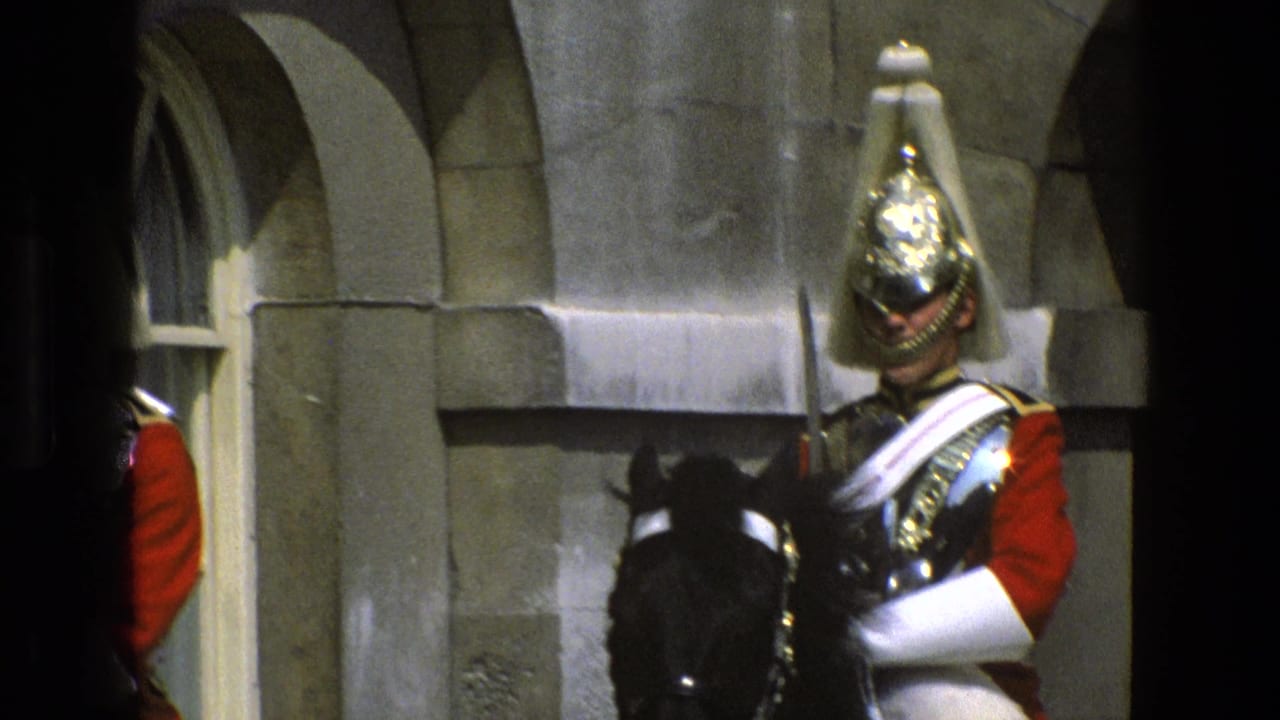 Mounted ceremonial guard in red uniform holding a sword near a stone archway.