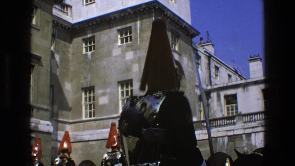A closer 1969 England view shows a mounted ceremonial guard in dark armor and a tall red plume against the stone courtyard buildings.