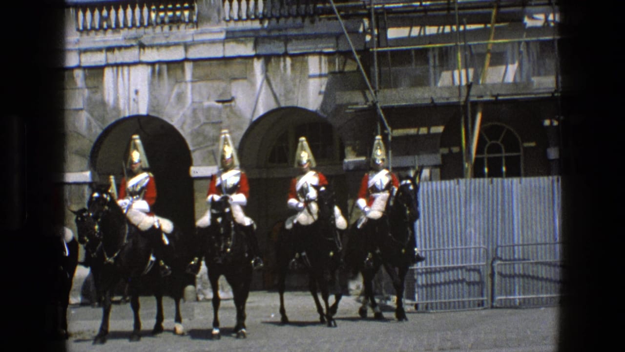 Mounted ceremonial cavalry line up on black horses outside a stone building with scaffolding.