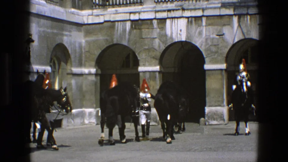 Ceremonial mounted guards and attendants appear near palace courtyard arches in England, based on supplied 1969 metadata.