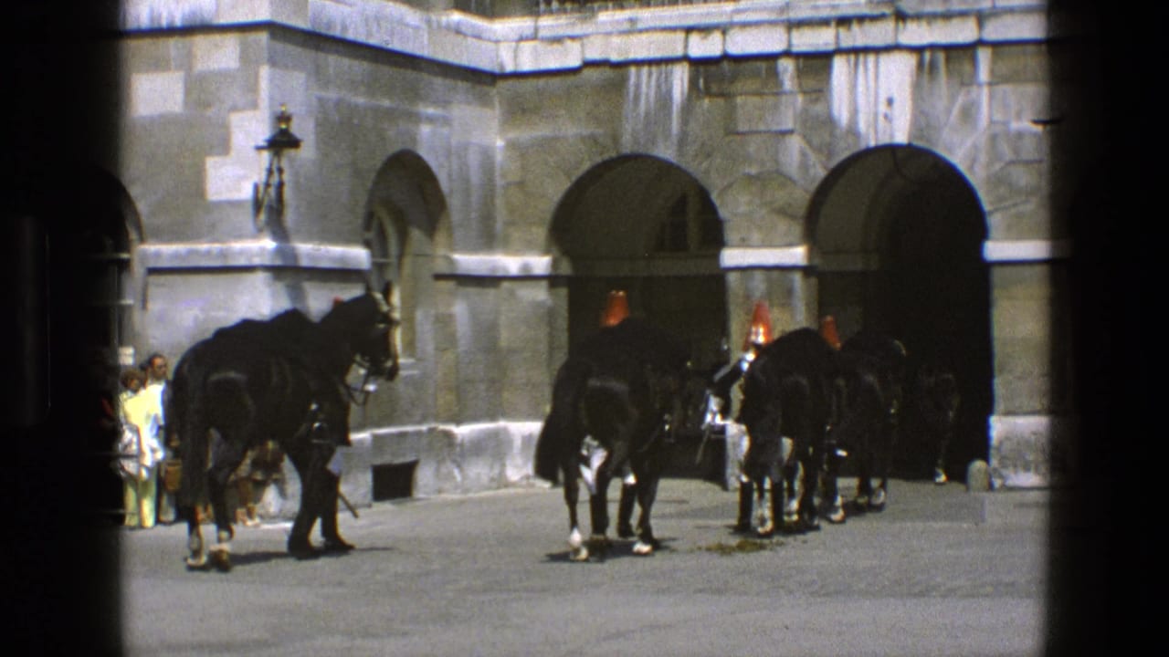 In 1969 England footage, ceremonial mounted guards and black horses gather by arched stone entrances while visitors watch nearby.
