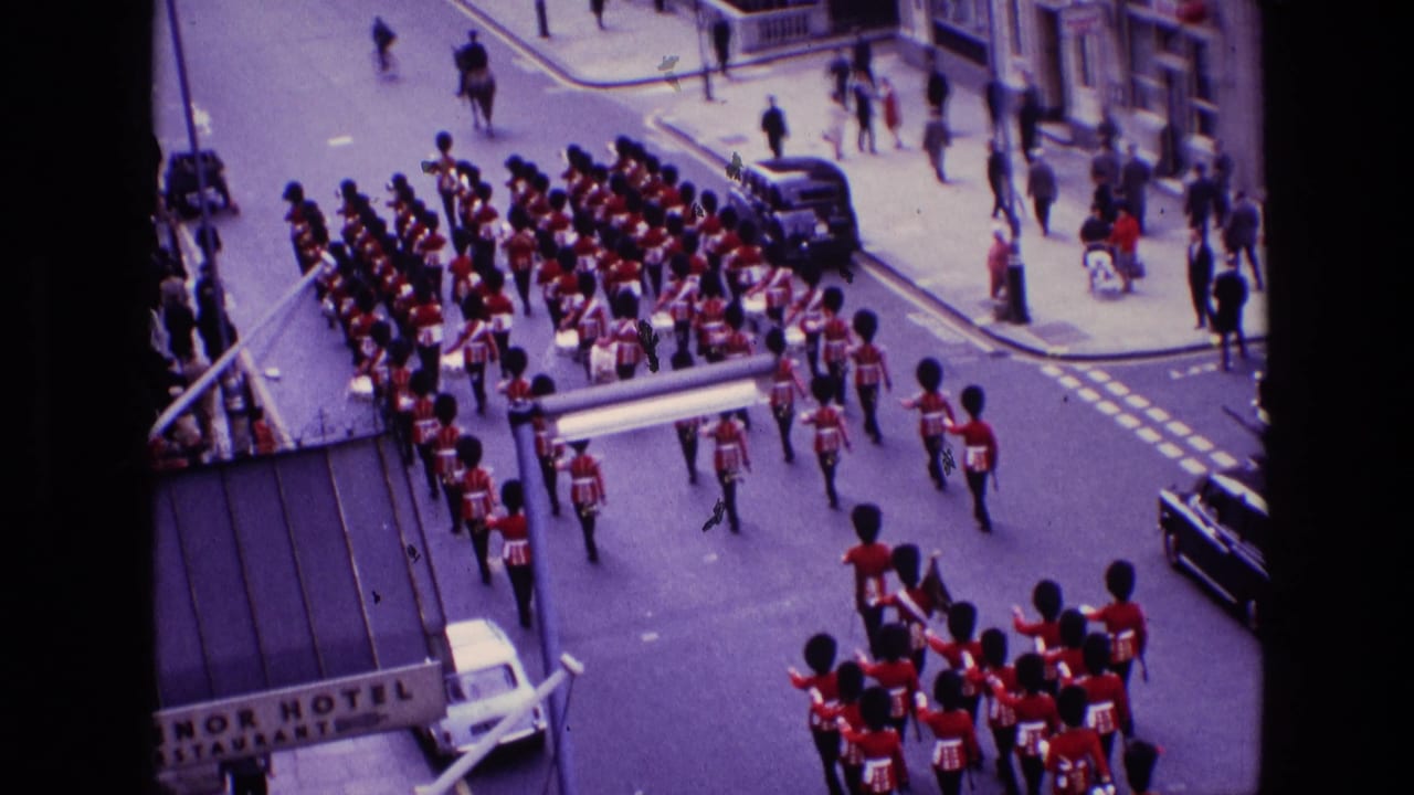 Large marching formation moves through an intersection with spectators nearby.
