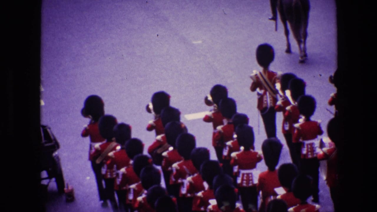 Elevated 8mm view of uniformed band members in red ceremonial dress marching in formation during an Ireland parade.