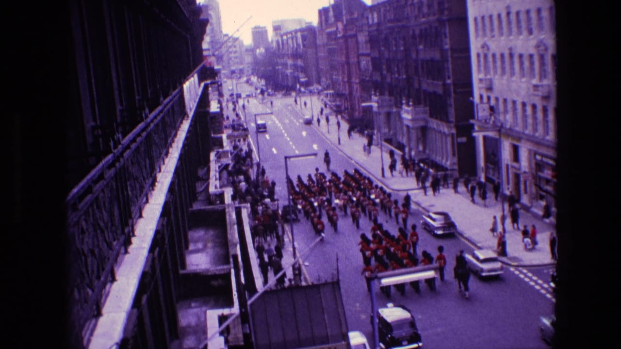Marching formation continues along the street with pedestrians and cars nearby.