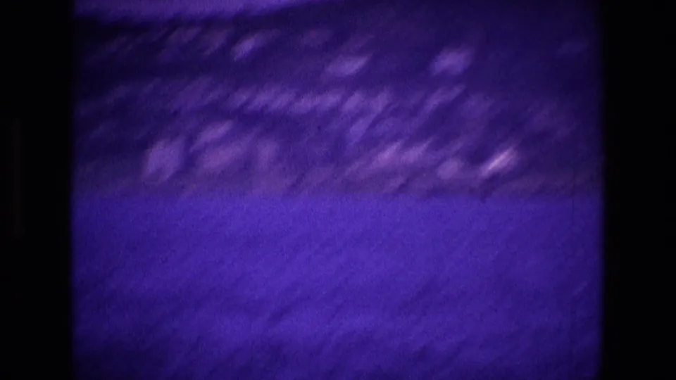 Motion-blurred 1969 Ireland 8mm view of the shoreline and water as the handheld camera moves across the coastal scene.