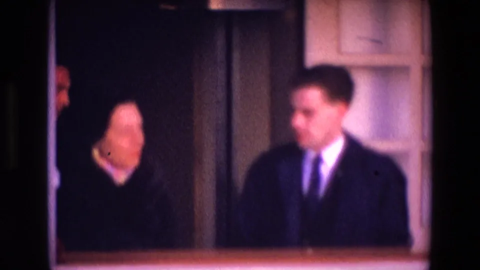 Near the end of the clip, two adults appear to converse in a softly focused 1969 Ireland interior with white trim and dark walls.