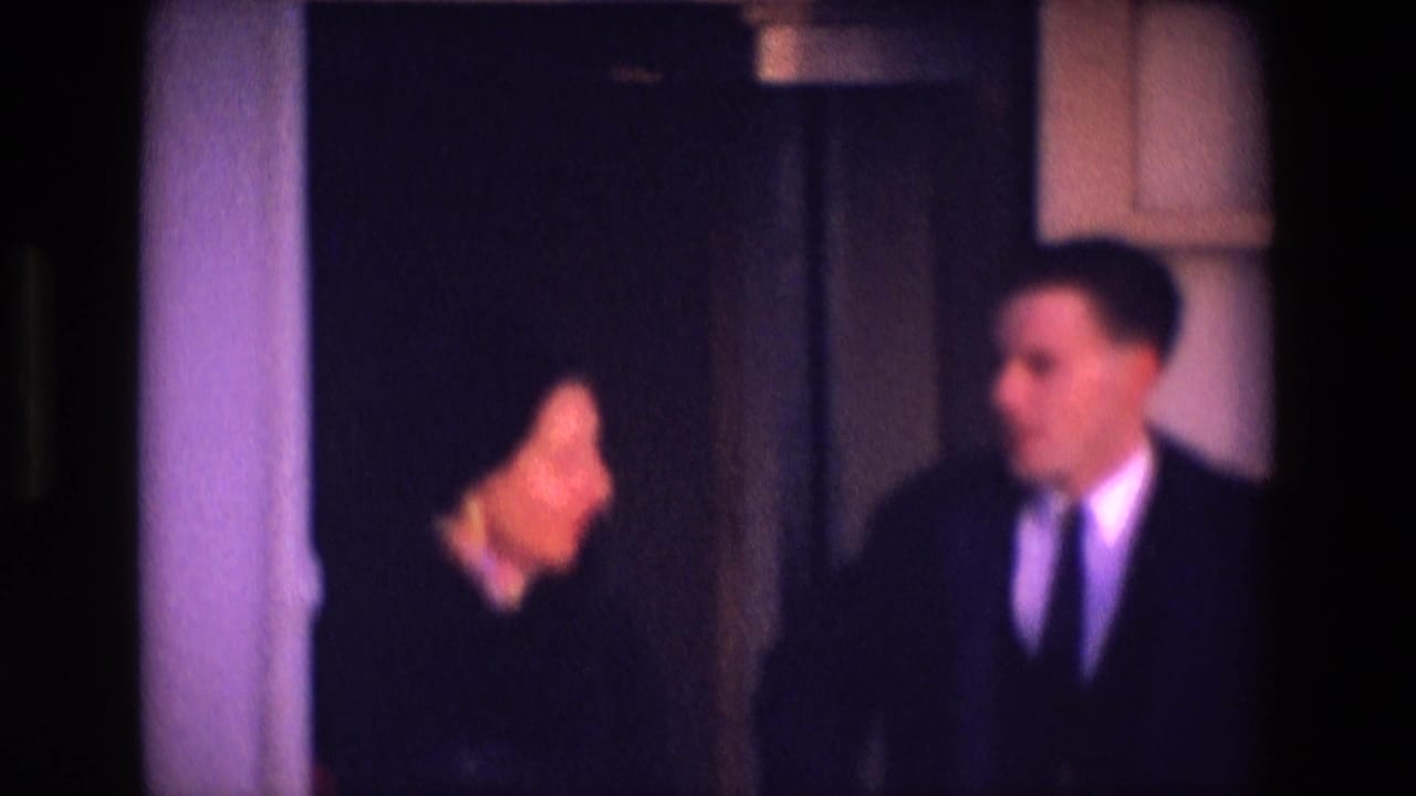 1969 Ireland travel frame with a woman in profile and a suited man beside a dark boat doorway, seen through a divided window area.