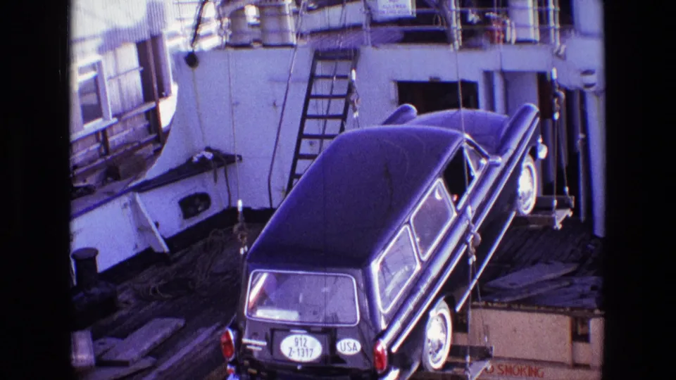 Rear view of the crane-lifted vehicle on a ship deck, with a round USA marking and license details visible.