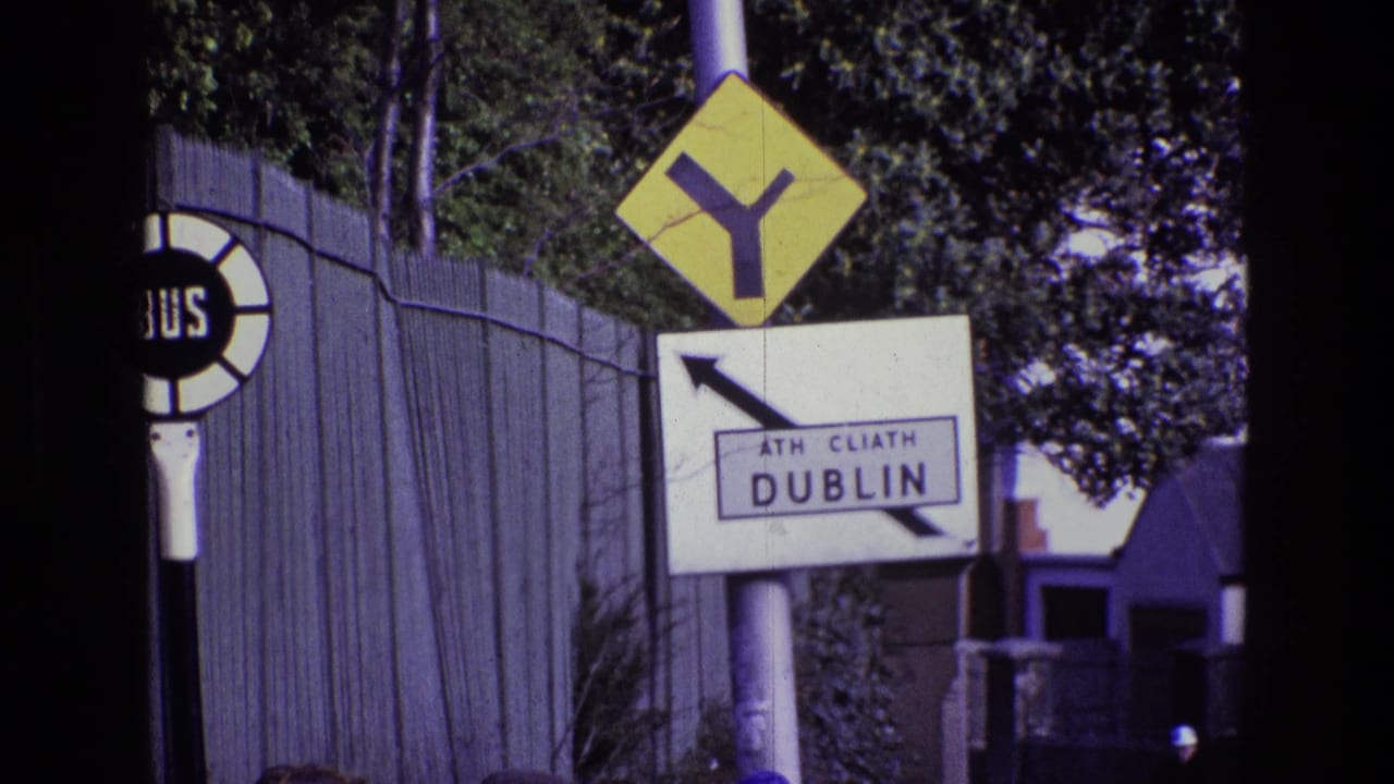 Dublin direction sign and yellow Y-intersection warning sign beside a partly visible bus stop marker.