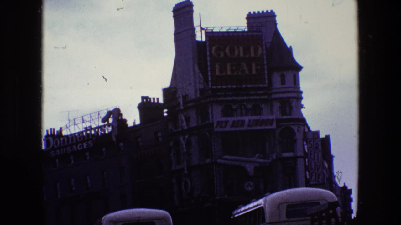 1969 Ireland street view with a Gold Leaf billboard, Fly Aer Lingus banner, bus roofline, and commercial signs on older buildings.