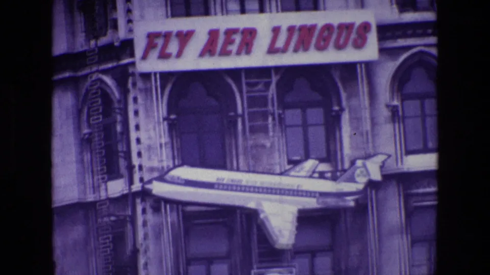 1969 Ireland 8mm frame where the airline sign and mounted airplane model dominate the building-front view.