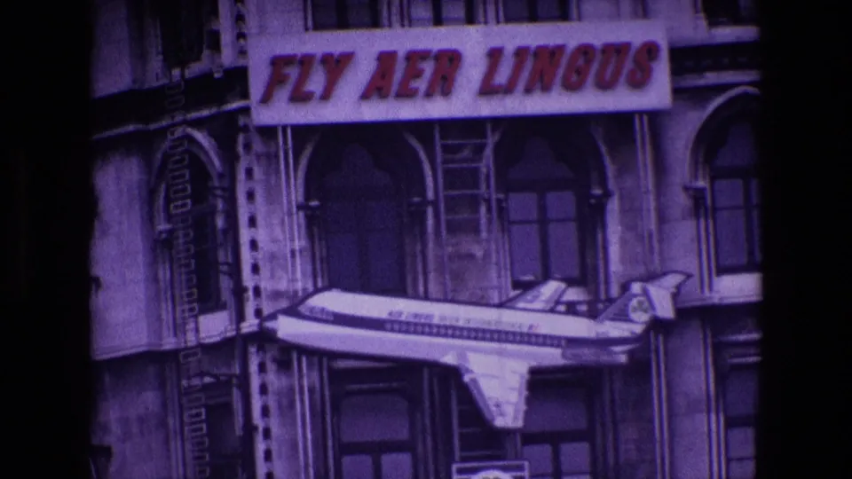 End frame of the 1969 Ireland zoom, centered on the FLY AER LINGUS sign and airplane model against the building facade.
