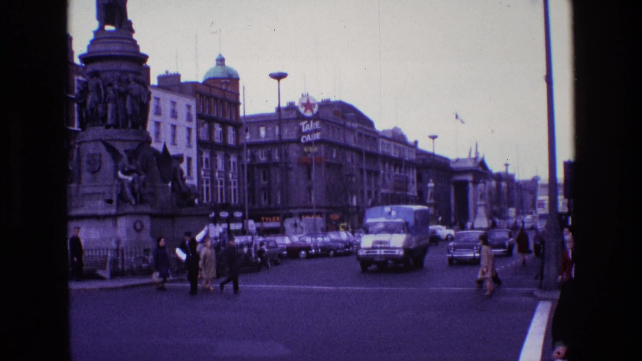 Traffic and pedestrians move through an intersection beside a large monument.