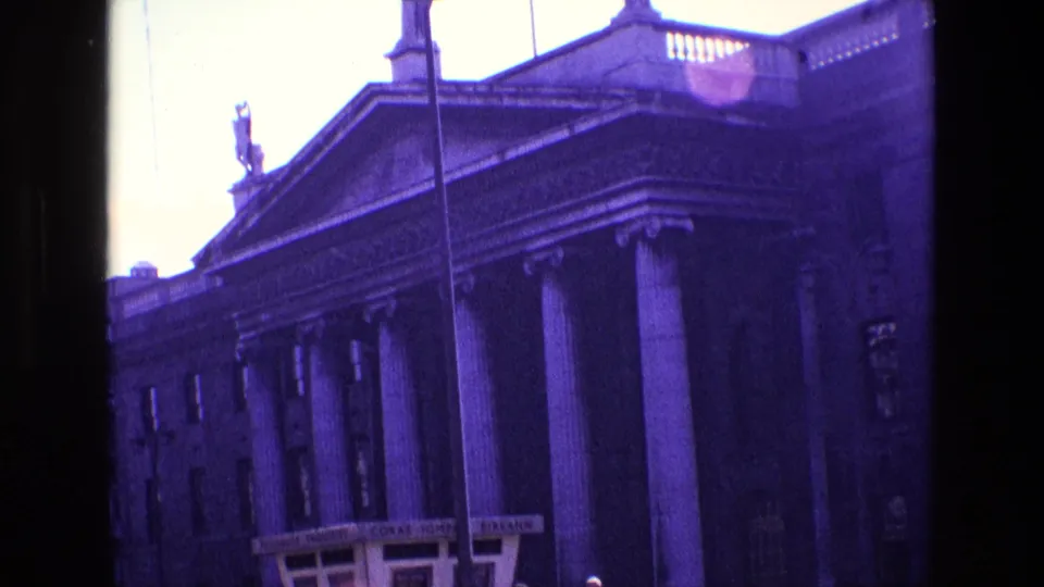 The 1969 Ireland clip ends on a closer handheld view of the columned building, with bus signage and street details below.