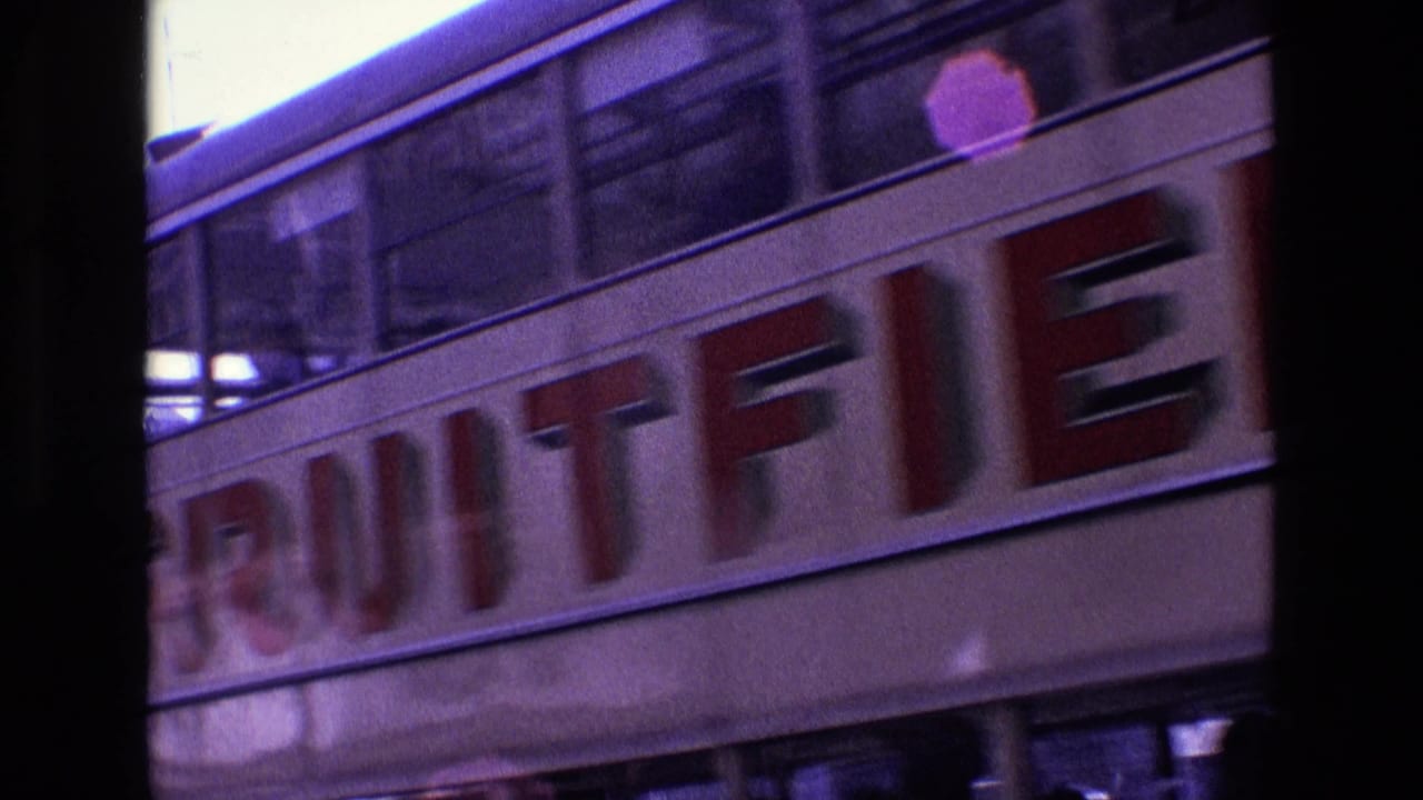 1969 Ireland 8mm frame with a trolley passing close to the camera and partly blocking a neoclassical building.