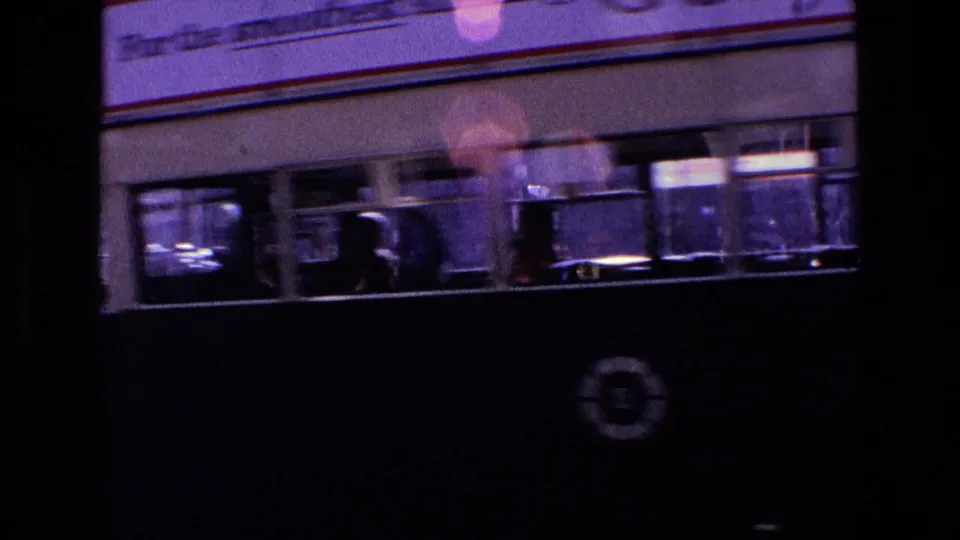 1969 Ireland street footage with a passing bus in the foreground and blurred passengers or reflections in the windows.