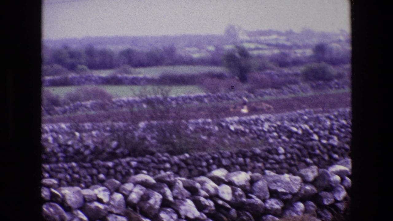 1969 Ireland home-movie view of stone-walled fields and a distant rural valley landscape.