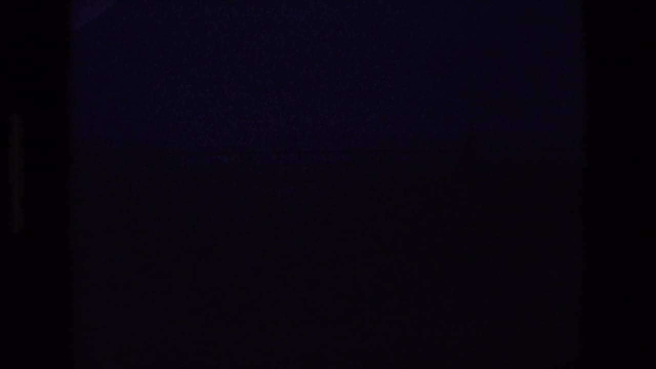 Dark lead-in frame with only faint film texture visible.