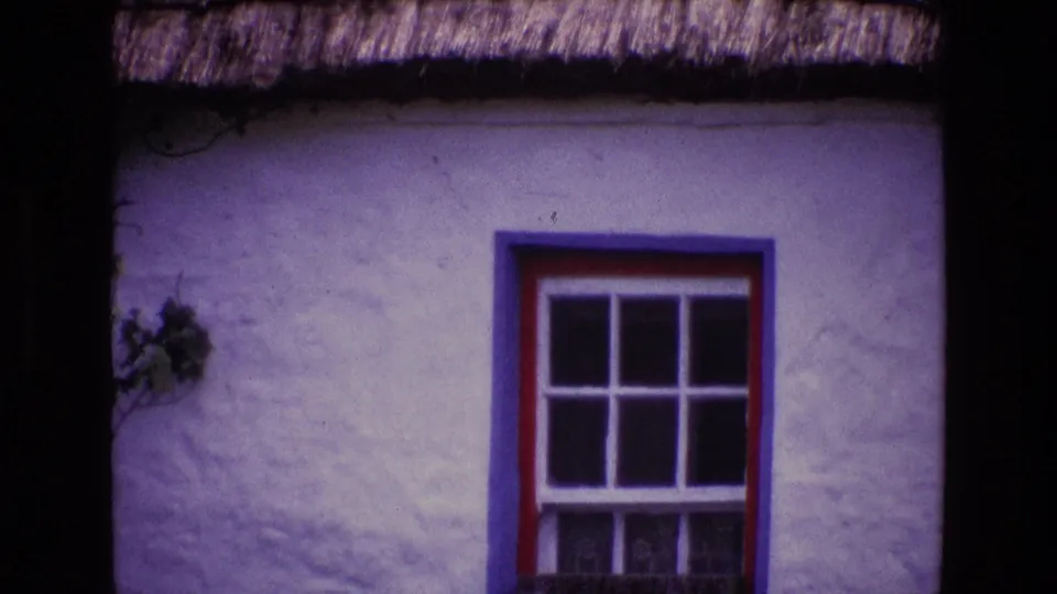Ireland 1969 cottage exterior detail with a red and blue window frame against rough white stucco.