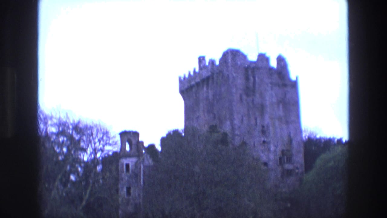 Dark castle tower and ruined wall seen through 8mm film-frame edges.