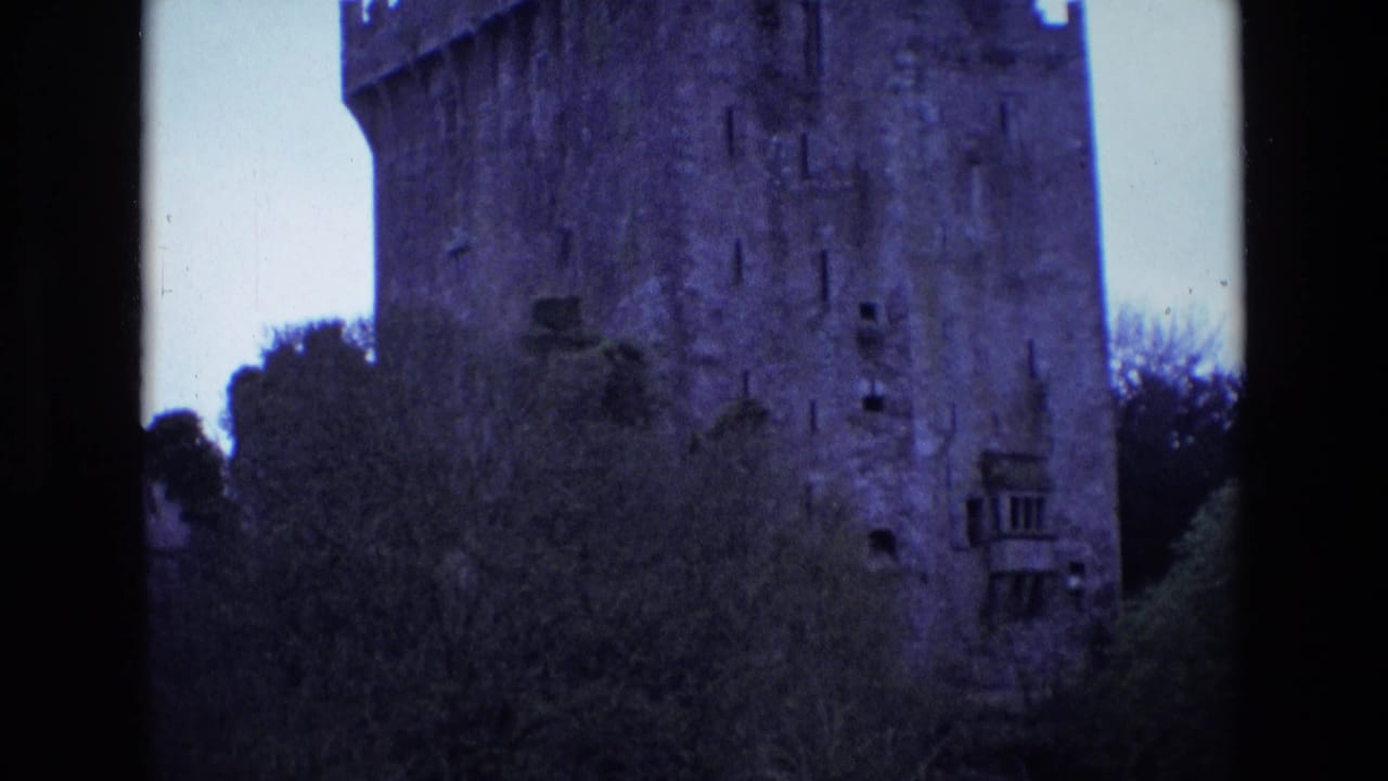 1969 Ireland 8mm frame with a closer exterior view of the castle wall, crenellations, narrow openings, and trees below.
