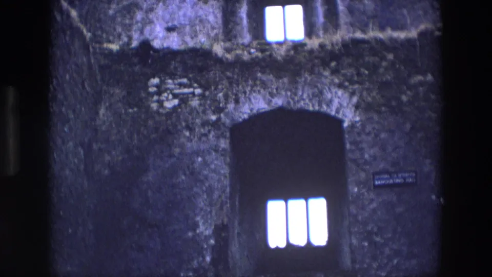 1969 Ireland frame showing a dark arched doorway below three bright narrow window openings in a stone castle interior.