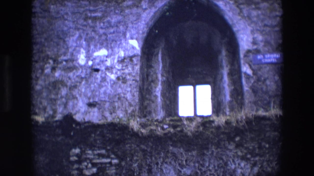 Arched stone recess with two bright window panes and a chapel sign nearby.