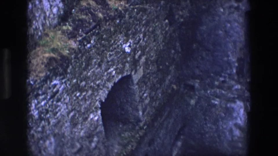 Final 1969 Ireland frame showing the chapel entrance area from a tilted, grainy home-movie angle.