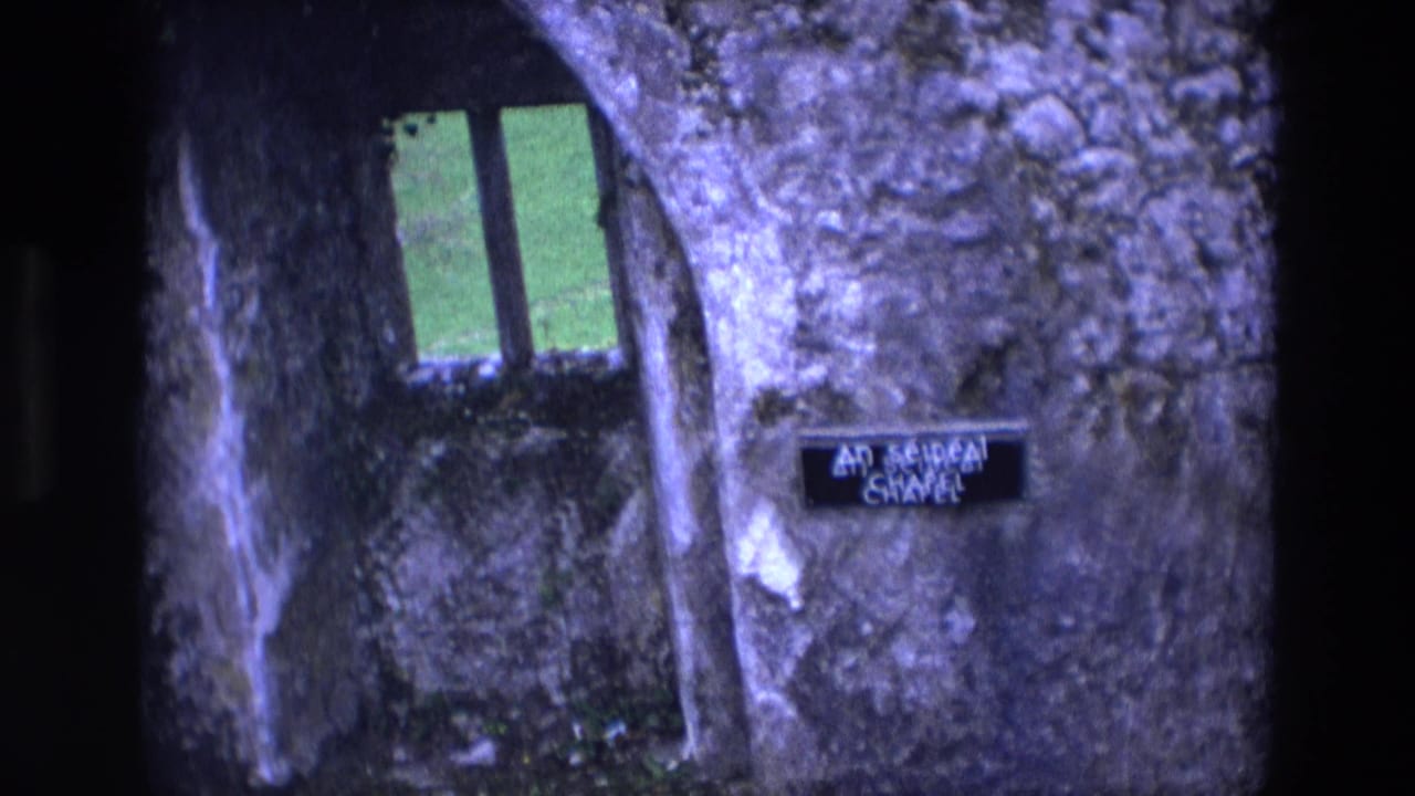 Arched chapel opening with a narrow window and a small chapel sign on the stone wall.
