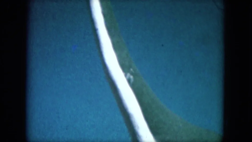 1969 8mm frame from Lake Canyon showing the white-striped green form at a slightly different angle over blue.