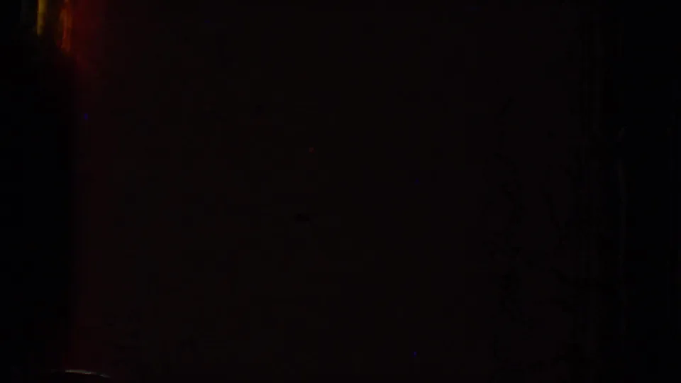 Dark 8mm frame from the 1969 Lake Canyon clip with faint red, blue, and black exposure variation.