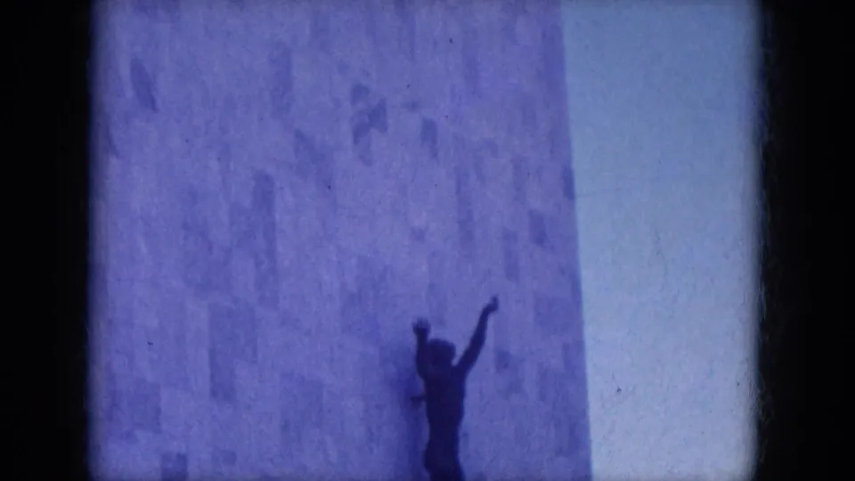 The 1969 home movie lingers on the mounted human-form sculpture against the modernist stone facade in Lake Canyon, Arizona.