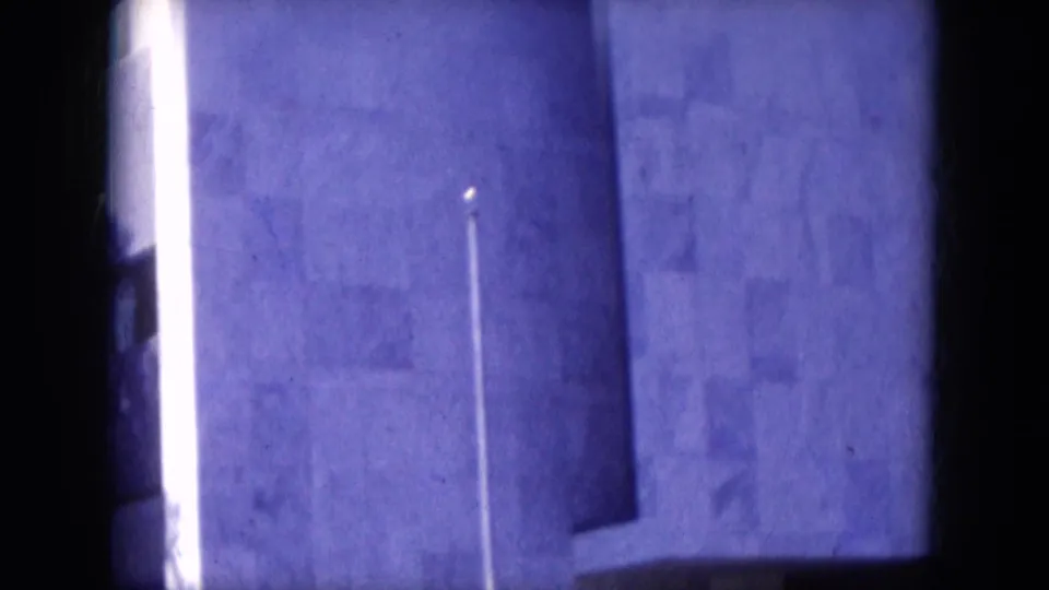 Lake Canyon, Arizona 1969 metadata frame showing a pale urban facade, bright vertical light, and a small silhouetted person near the lower edge.