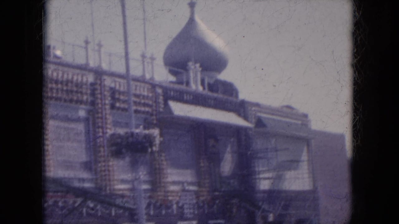 Ornate building facade with dome, trim, windows, and street-level awning.