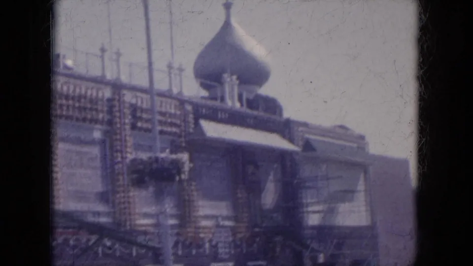 1969 Arizona 8mm frame showing an ornate exterior with a prominent dome, patterned trim, upper windows, and a shaded street frontage.