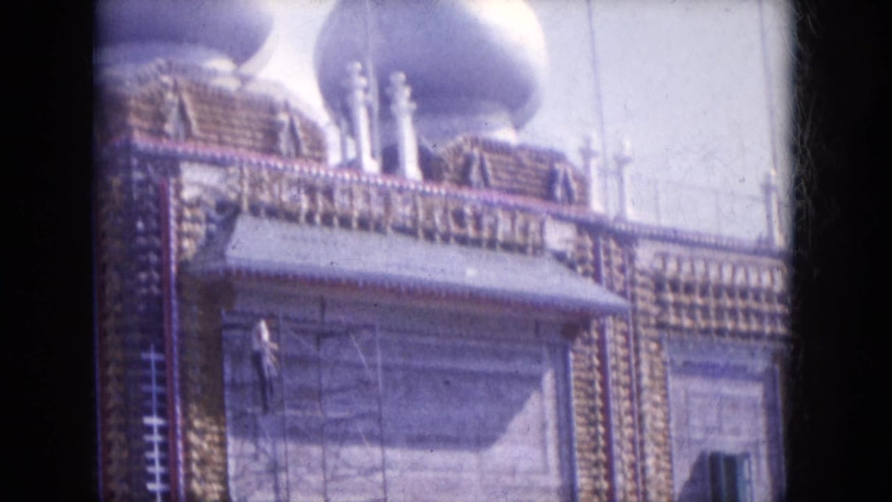 Ornate domed building with scaffolding and a worker visible on the facade.