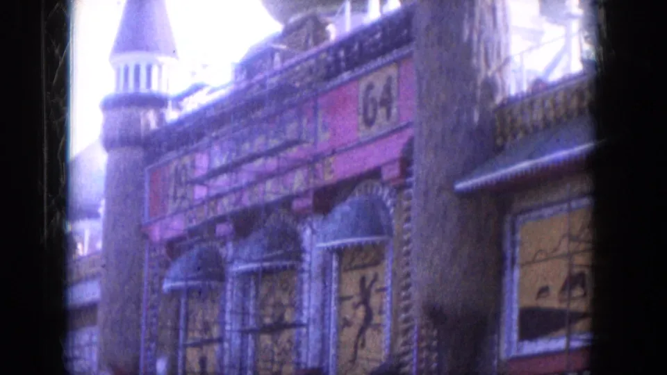 1969 Lake Canyon, Arizona frame with a numbered sign on an ornate painted facade, scaffolding, covered windows, and a tower-like roofline behind.