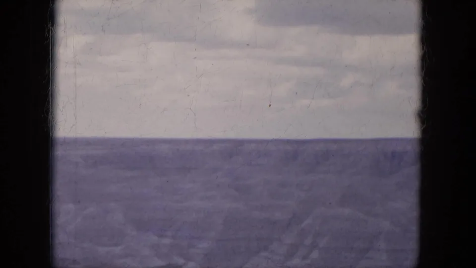 1969 Lake Canyon, Arizona 8mm frame showing pale clouds over a wide water horizon with dark scan borders.