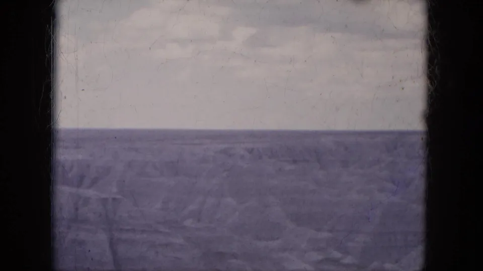 Wide Lake Canyon water view under a muted sky, with faded 8mm color and visible film-frame edges.