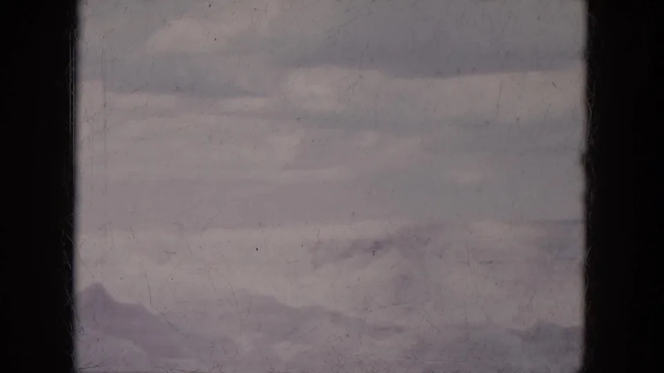 1969 Lake Canyon, Arizona home-movie frame showing hazy ridges, a pale sky, and dark vertical film-edge shadowing.