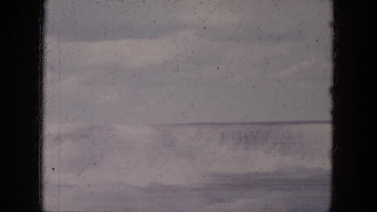 1969 Lake Canyon, Arizona frame with a muted distant mountainside, pale sky, and prominent dark vertical film-edge band.