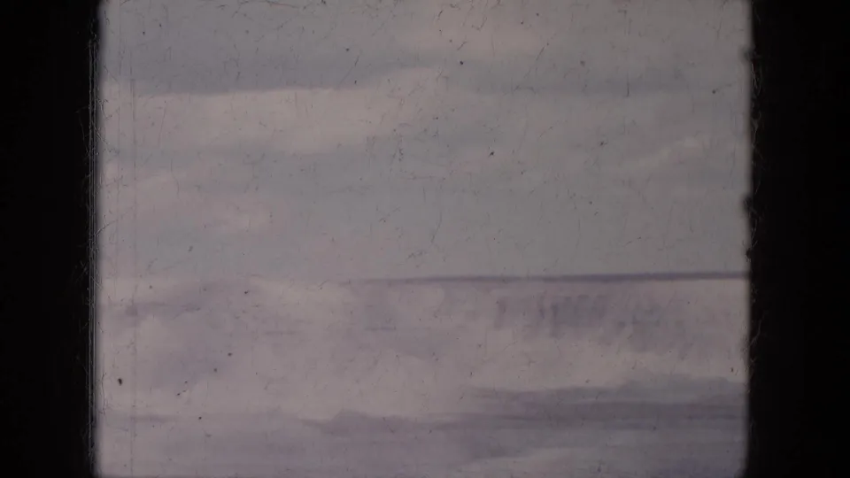 1969 Lake Canyon, Arizona frame with a muted distant mountainside, pale sky, and prominent dark vertical film-edge band.