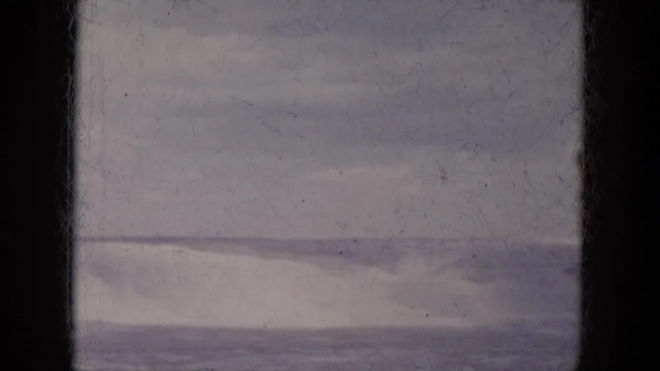 1969 Lake Canyon, Arizona frame showing a pale desert hillside, distant horizon, and dark vertical film borders.